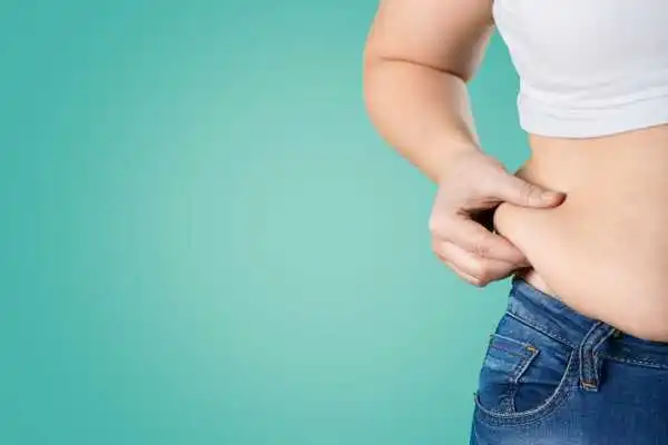 Image of woman pinching her love handles to show weight gain Cambridge