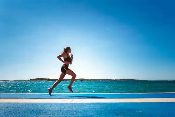 Woman running showing strong leg muscle Cambridge